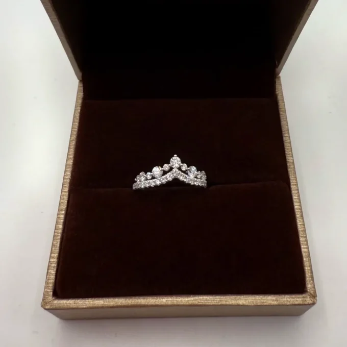 Delicate crown-style diamond ring in a brown velvet presentation box, white gold band shimmering. A perfect engagement or bridal gift showcased elegantly.